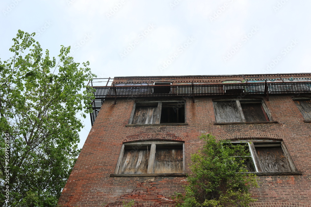 Old abandoned condemned brick building with broken boarded up glass windows Old abandoned condemned brick building with broken boarded up glass windows