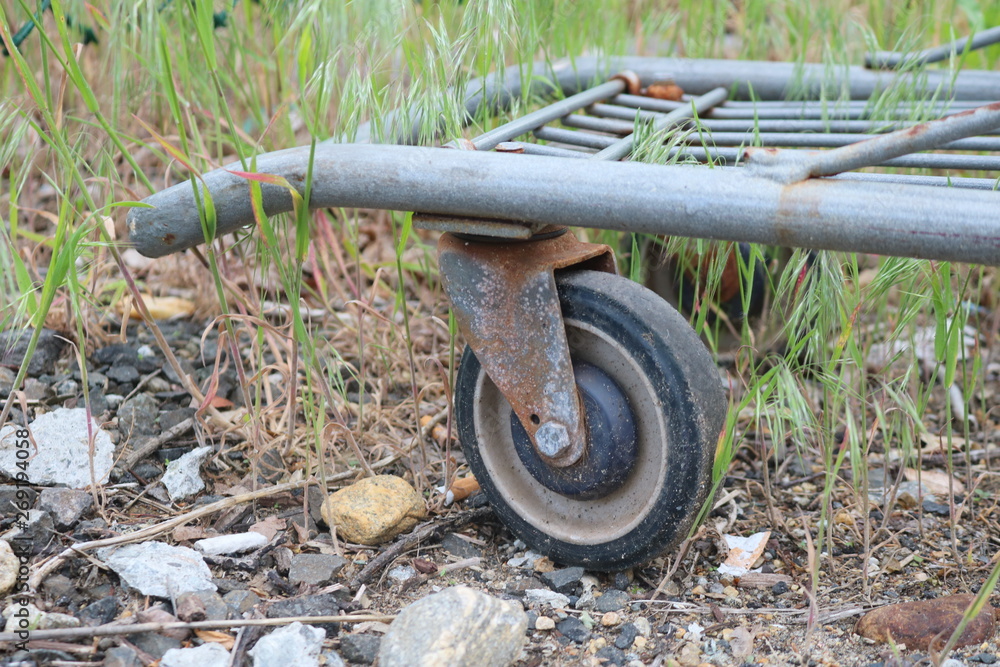 Fototapeta premium Old rusty abandoned metal shopping cart left outside 