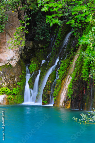 small waterfall among green stones