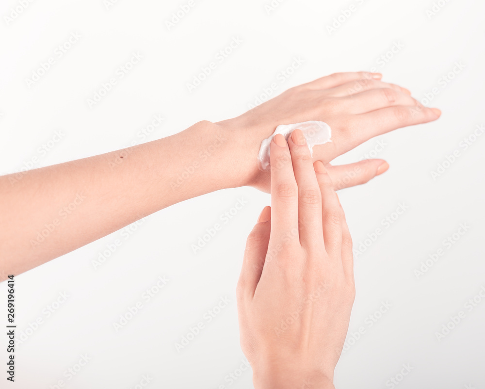 Spa treatment. Close Up of female hands applying hand cream. Woman holding cream tube and applying moisturizer cream on her beautiful hands for clean and soft skin. Spa treatment. Close Up of female hands applying hand cream. Woman holding cream tube and applying moisturizer cream on her beautiful hands for clean and soft skin.