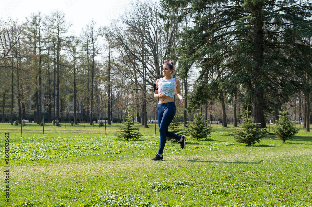 slender girl running in the Park among the greenery, runner slender girl running in the Park among the greenery, runner