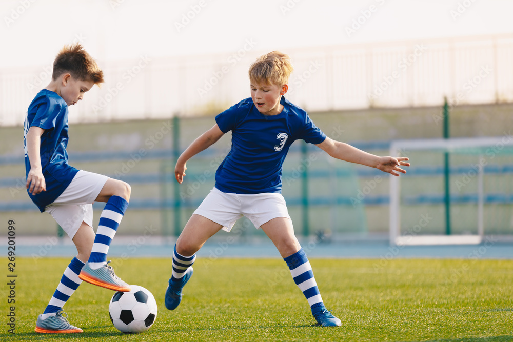 Two Junior Soccer Players Training with Soccer Ball on Stadium Grass Pitch