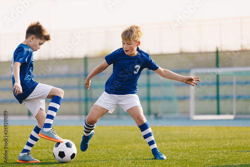 Two Junior Soccer Players Training with Soccer Ball on Stadium Grass Pitch