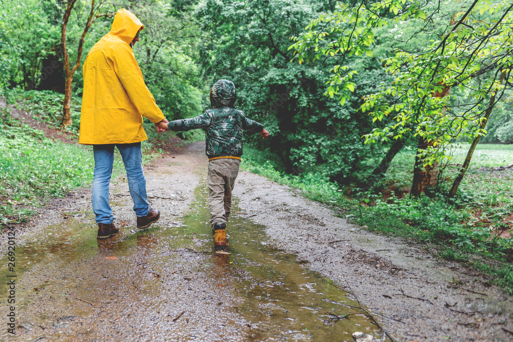 Father and son walking in the rain Father and son walking in the rain