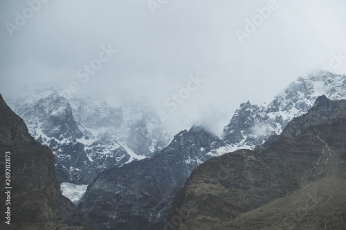 Nature landscape view of clouds and fog covered snow capped Ultar Sar mountain in Karakoram range, Hunza valley. Gilgit Baltistan, Pakistan. © Sulo Letta
