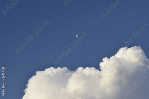 Céu azul, nuvem cumulus e Lua durante o dia