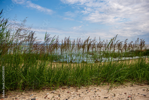 empty sea beach in summer with waves and broken clouds