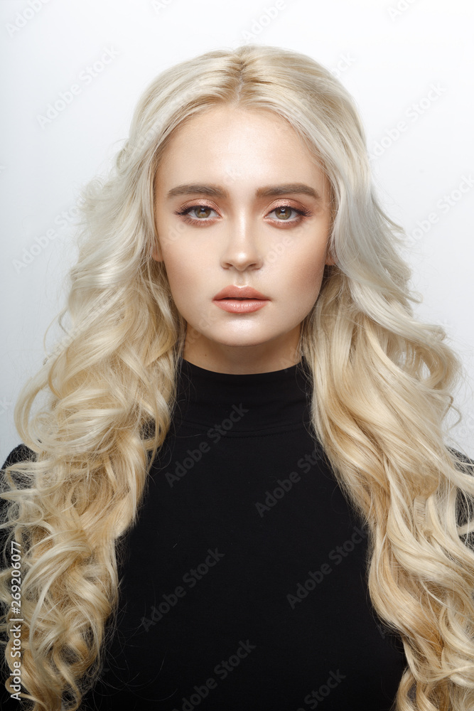 Frontal portrait of a cute blonde girl, with delicate make up, curly shiny long hair, isolated of a white background. Frontal portrait of a cute blonde girl, with delicate make up, curly shiny long hair, isolated of a white background.