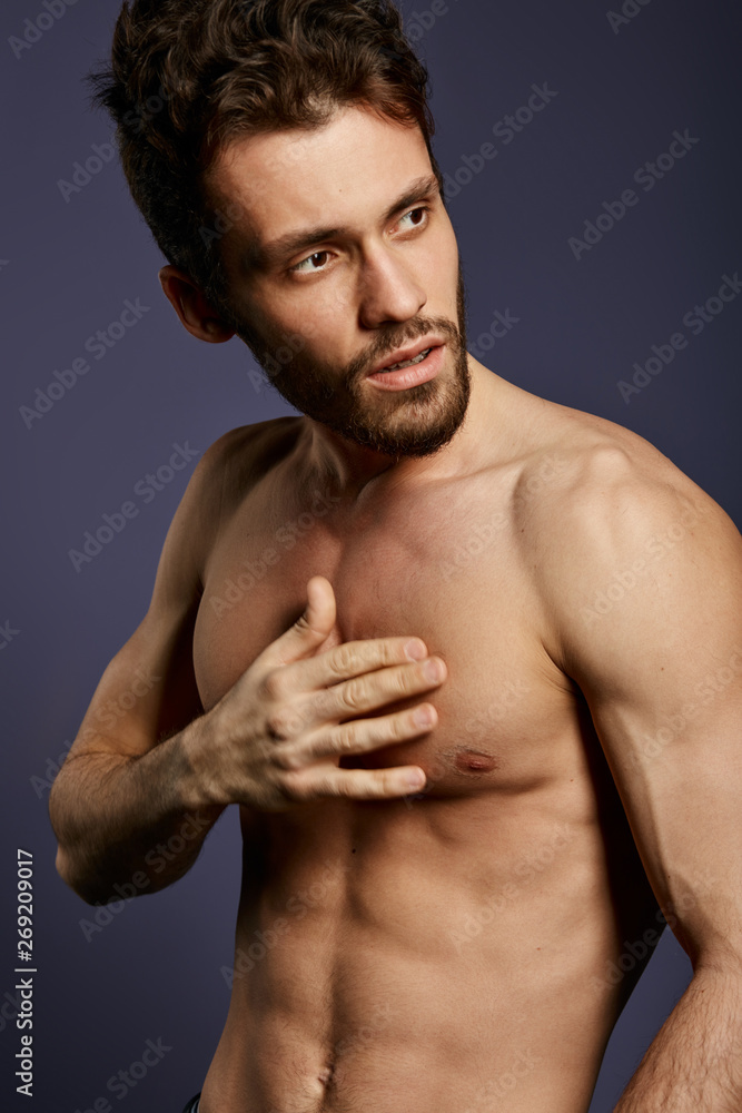 pensive fitness model with hand on his breast posing to the camera. close up side view photo. pensive fitness model with hand on his breast posing to the camera. close up side view photo.