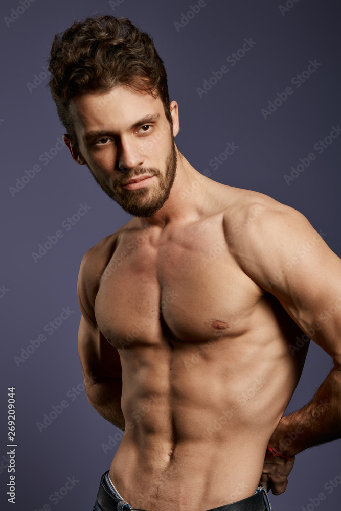 shirtless strong muscular guy standing in the studio with black wall. close up photo. sexuality concept.the beauty of body shirtless strong muscular guy standing in the studio with black wall. close up photo. sexuality concept.the beauty of body