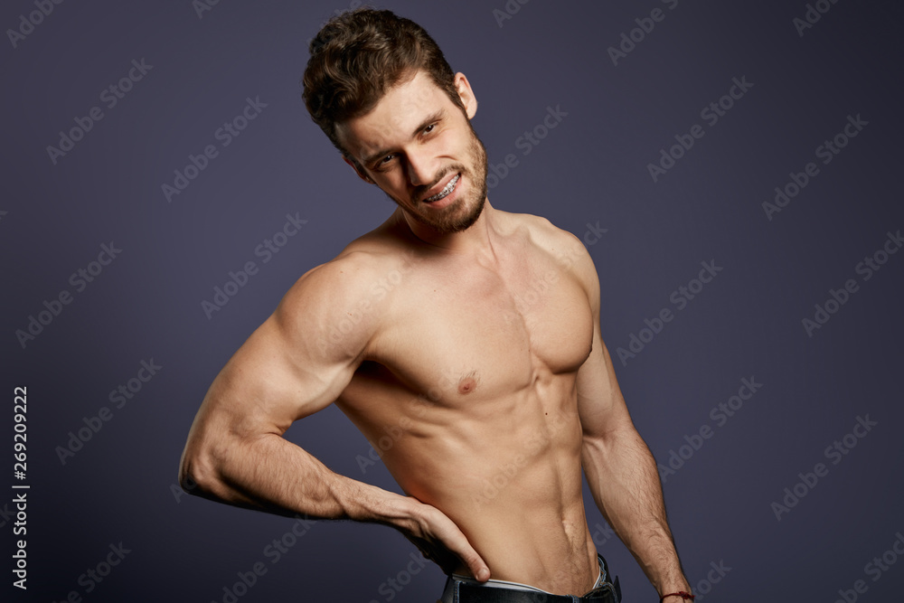 Obraz premium shirtless young man suffering from backache.close up photo. isolated black background . negative emotion and feeling