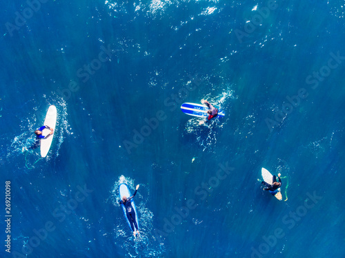 Group of novice surfers are learning to embark on wave. Aerial top view