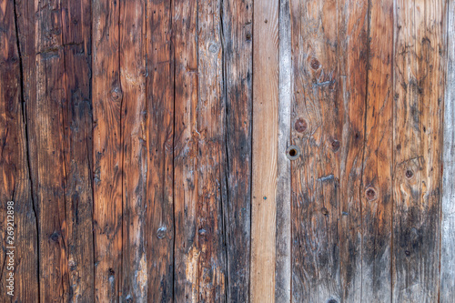 Closeup of traditional weathered outhouse wood panel doors with keyhole