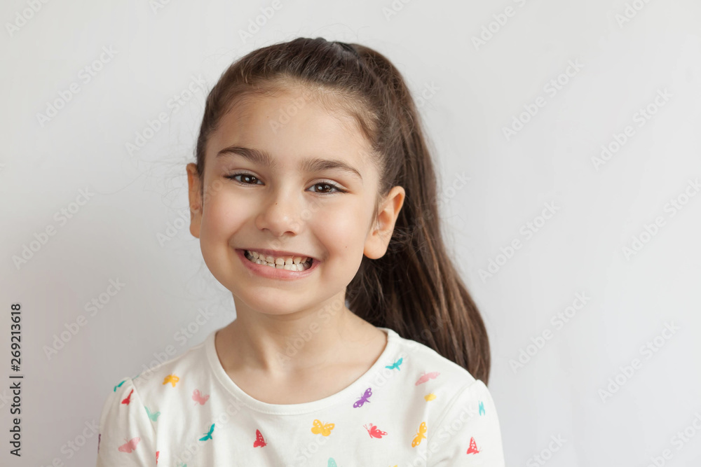 Portrait of happy smiling child girl on light background. Laughing people. Positive emotions. Portrait of happy smiling child girl on light background. Laughing people. Positive emotions.