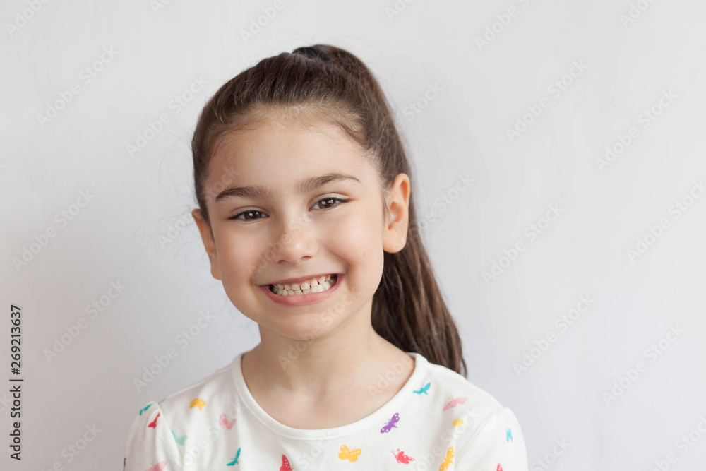 Portrait of happy smiling child girl on light background. Laughing people. Positive emotions. Portrait of happy smiling child girl on light background. Laughing people. Positive emotions.