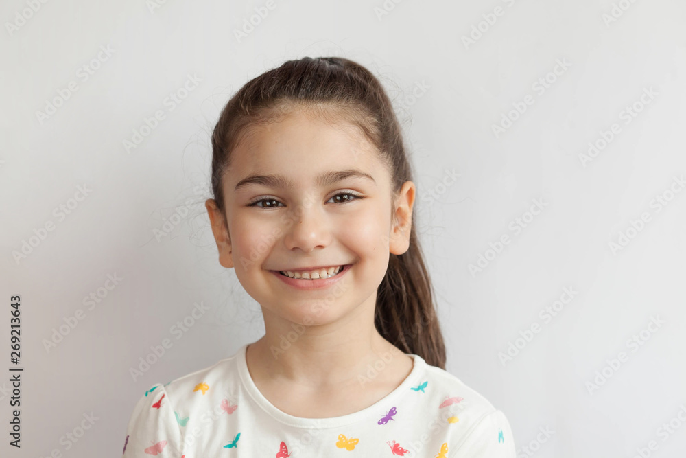 Portrait of happy smiling child girl on light background. Laughing people. Positive emotions. Portrait of happy smiling child girl on light background. Laughing people. Positive emotions.