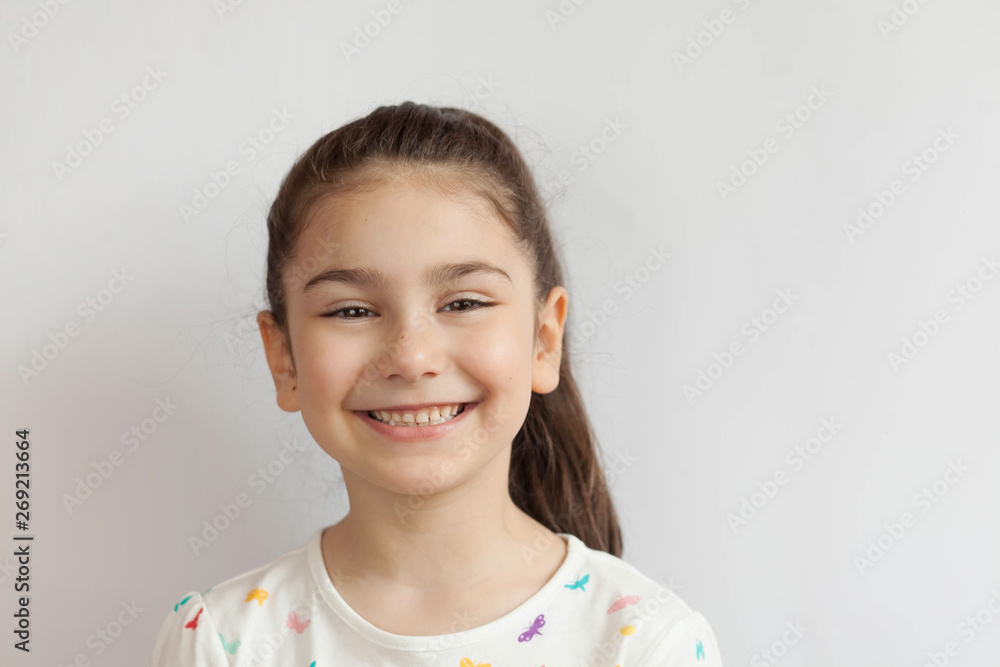Portrait of happy smiling child girl on light background. Laughing people. Positive emotions. Portrait of happy smiling child girl on light background. Laughing people. Positive emotions.
