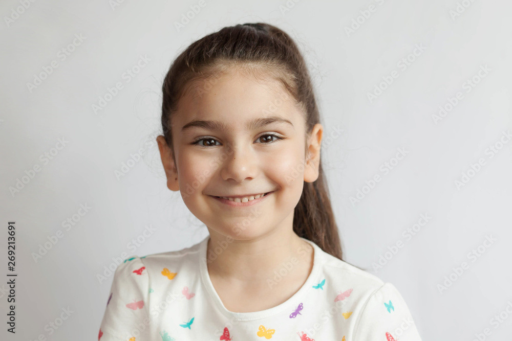 Portrait of happy smiling child girl on light background. Laughing people. Positive emotions. Portrait of happy smiling child girl on light background. Laughing people. Positive emotions.