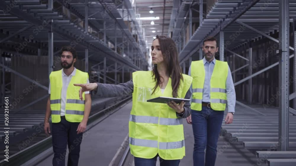 Chief engineer explaining factory work process to two new employees Chief engineer explaining factory work process to two new employees