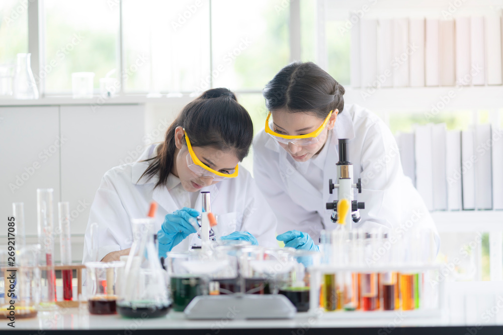 Female scientists are preparing microscopes for testing and analysis through an extension to find the results of medical research. Scientific and chemical concepts Female scientists are preparing microscopes for testing and analysis through an extension to find the results of medical research. Scientific and chemical concepts