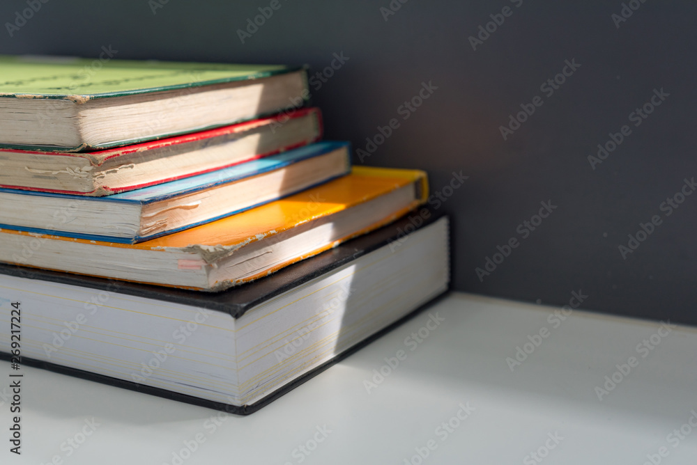 Close up books stacked on the table at the university library in selective focus. Close up books stacked on the table at the university library in selective focus.
