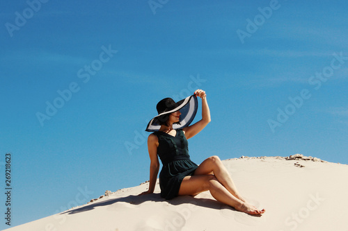 People, happiness, travel concept. Young adult brunette woman relaxing on a beach. 