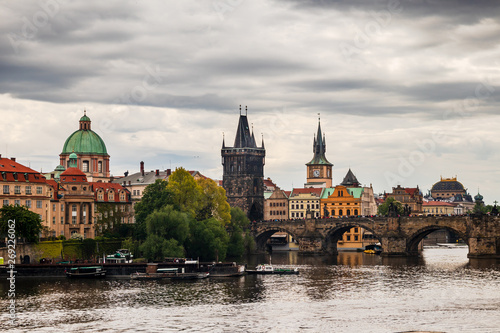 Tourist boats on Vltava river in Prague with Charles bridge and historic buildings in the background © Milan