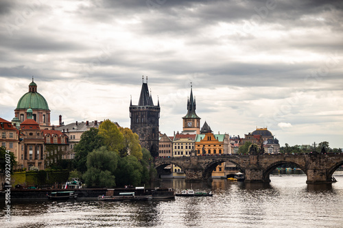 Tourist boats on Vltava river in Prague with Charles bridge and historic buildings in the background