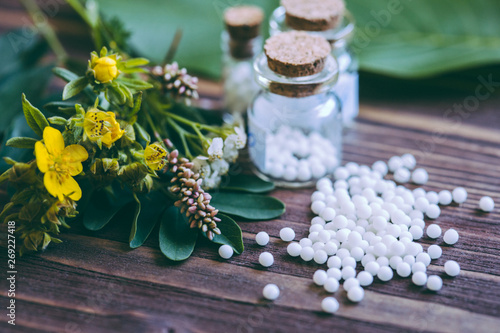 Homeopathic globules in small bottles, homeopathy concept