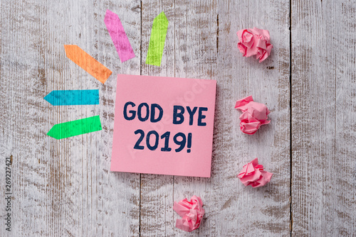 Handwriting text writing God Bye 2019. Conceptual photo express good wishes when parting or at the end of last year Plain note paper and line arrow stickers on the top of wooden table desk