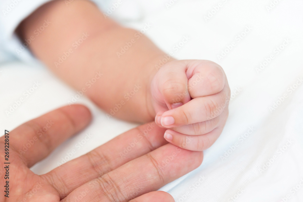 Tiny newborn baby hand on male hands closeup. Happy Family concept. Beautiful conceptual image of Maternity. Tiny newborn baby hand on male hands closeup. Happy Family concept. Beautiful conceptual image of Maternity.