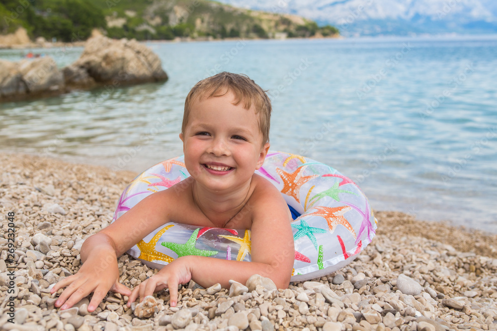 Little boy swims with inflatable ring in the sea. Little boy swims with inflatable ring in the sea.