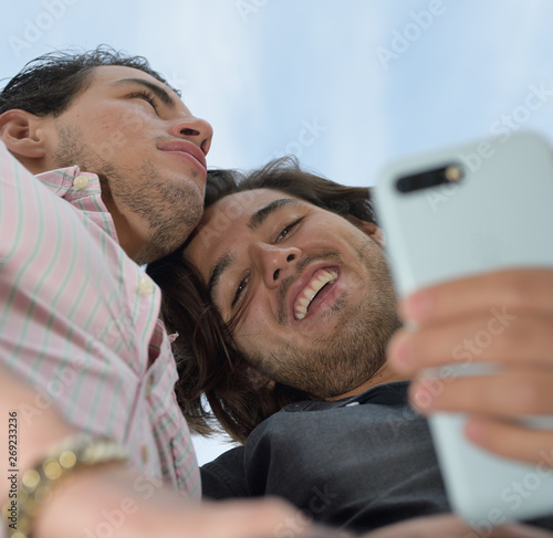 Happy gay couple enjoying with the mobile phone