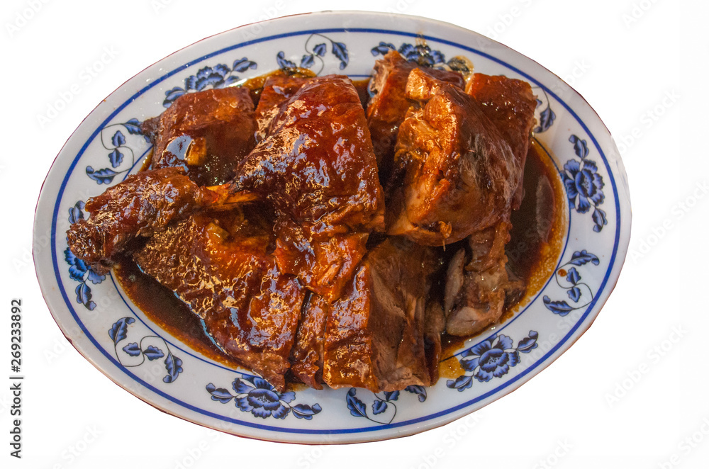 Chinese Roasted duck cut in piece and served on white dish topped with black gravy herbal sauce. Chinese Roasted duck cut in piece and served on white dish topped with black gravy herbal sauce.