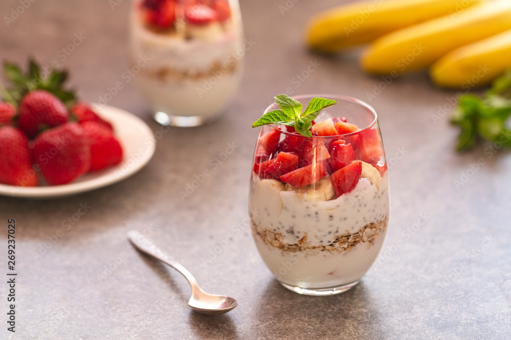 Homemade yogurt parfait with granola, strawberries, bananas and Chia seeds in glasses. Diet dessert with yogurt, Chia, muesli and fresh berries. Healthy breakfast Homemade yogurt parfait with granola, strawberries, bananas and Chia seeds in glasses. Diet dessert with yogurt, Chia, muesli and fresh berries. Healthy breakfast