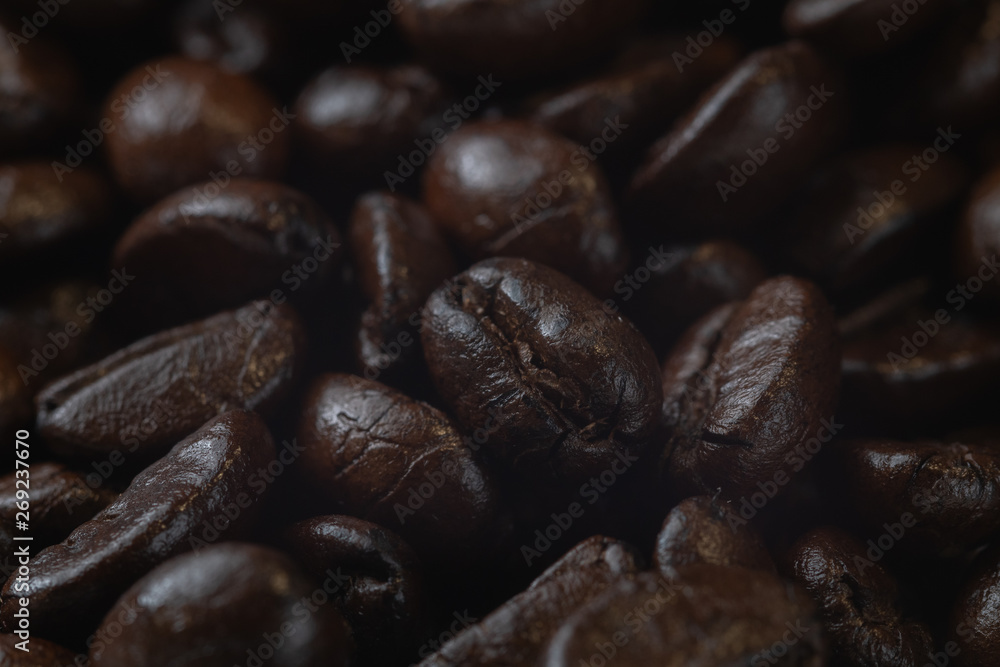 Naklejka premium close up of pile roast coffee beans on wooden board