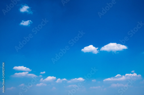 Beautiful clear blue sky with white fluffy clouds on a sunny day.