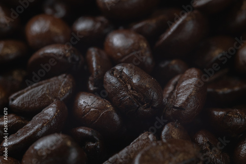 close up of pile roast coffee beans on wooden board © moxumbic