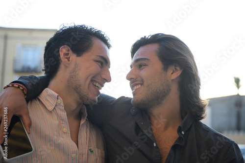 Gay couple embraced and looking closely