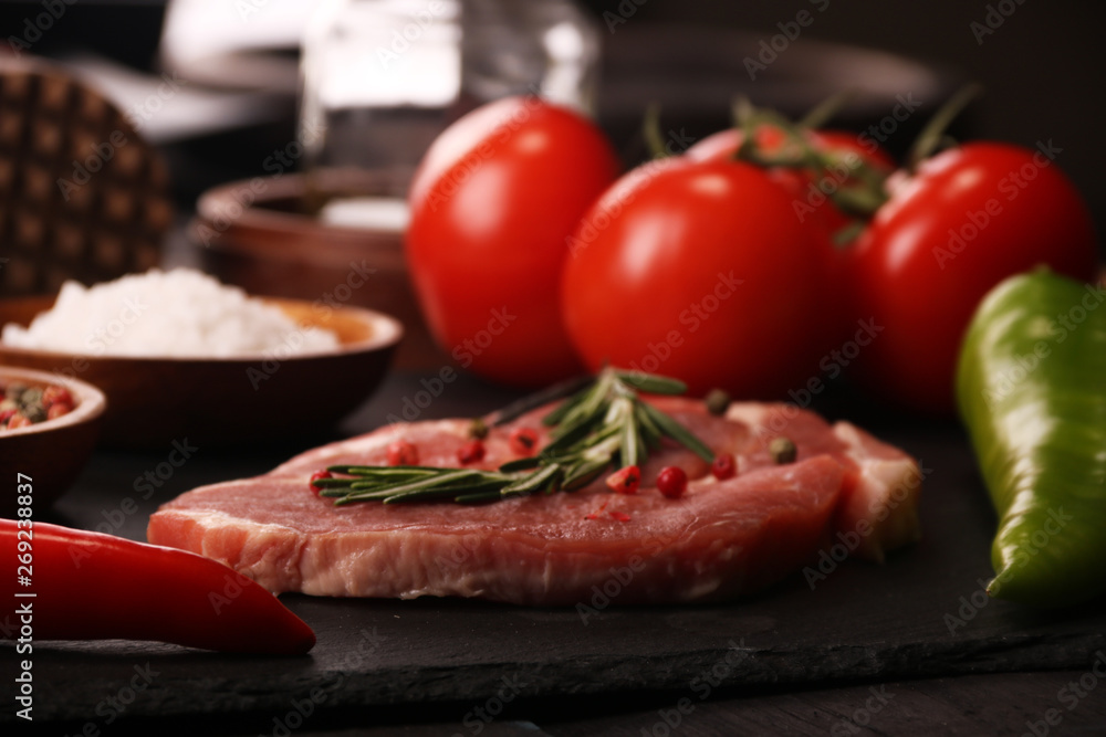 Raw pork meat steak with vegetables, peppers, tomato, salt, rosemary and spices cooking over stone table. Top view. Raw pork meat steak with vegetables, peppers, tomato, salt, rosemary and spices cooking over stone table. Top view.
