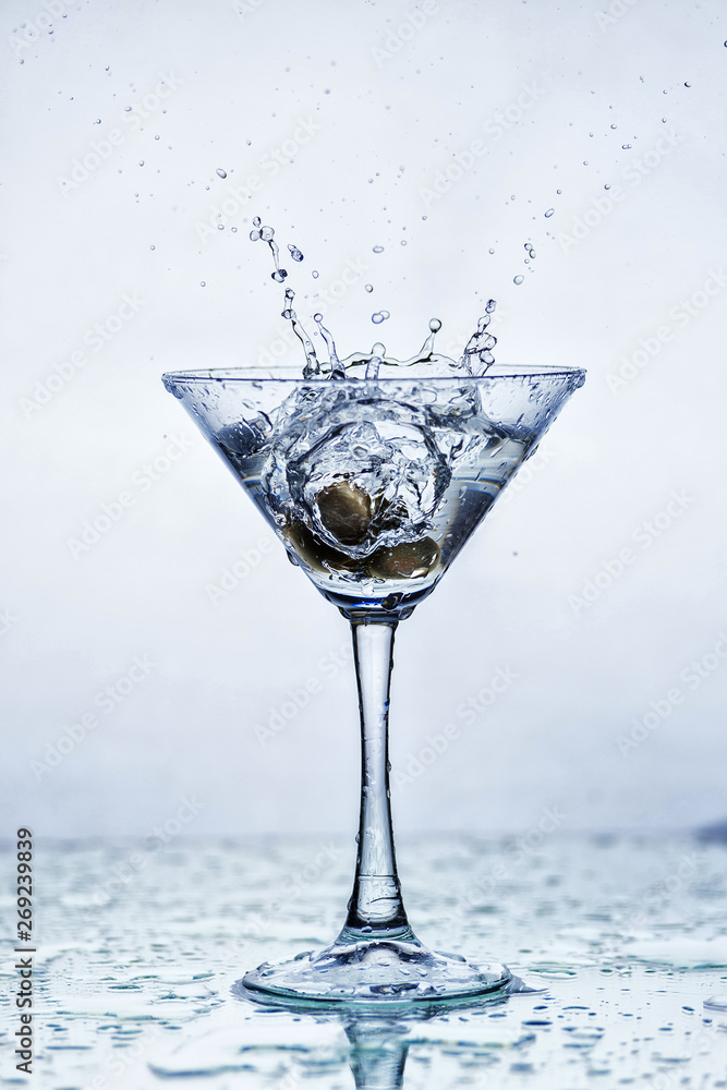 Foto de Martini glass with frozen splashing drops of drink do Stock