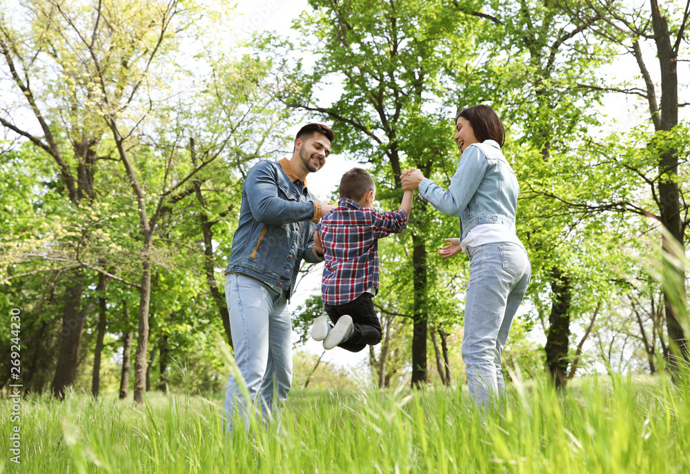 Little child having fun with his parents in park. Family weekend Little child having fun with his parents in park. Family weekend