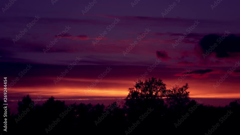 Day to night sky time lapse with trees illuminated by sunset. Evening clouds fast moving away. Beautiful nature scene in 4K. Day to night sky time lapse with trees illuminated by sunset. Evening clouds fast moving away. Beautiful nature scene in 4K.