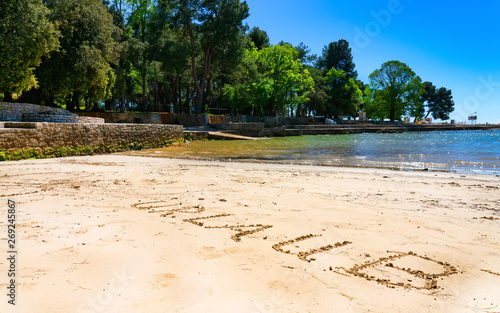 Fototapeta Naklejka Na Ścianę i Meble -  Urlaub ( Vacation), written in sand on the beach in Porec, Croatia