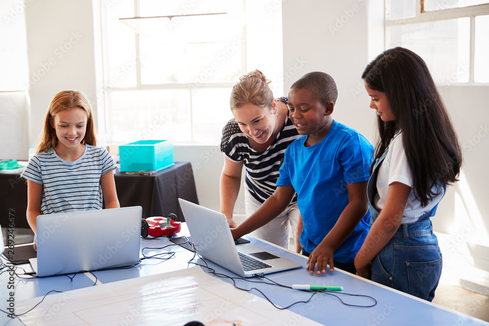 Group Of Students In After School Computer Coding Class Learning To Program Robot Vehicle Group Of Students In After School Computer Coding Class Learning To Program Robot Vehicle