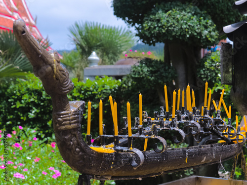 traditional buddhist candlestick with candles in the wat chalong temple. blurred background