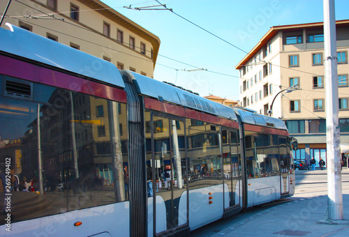 an urban tram runs through the chaos of city streets to bring commuters to their destination