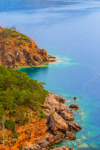 closeup rocky sea coast  red rock and emerald sea