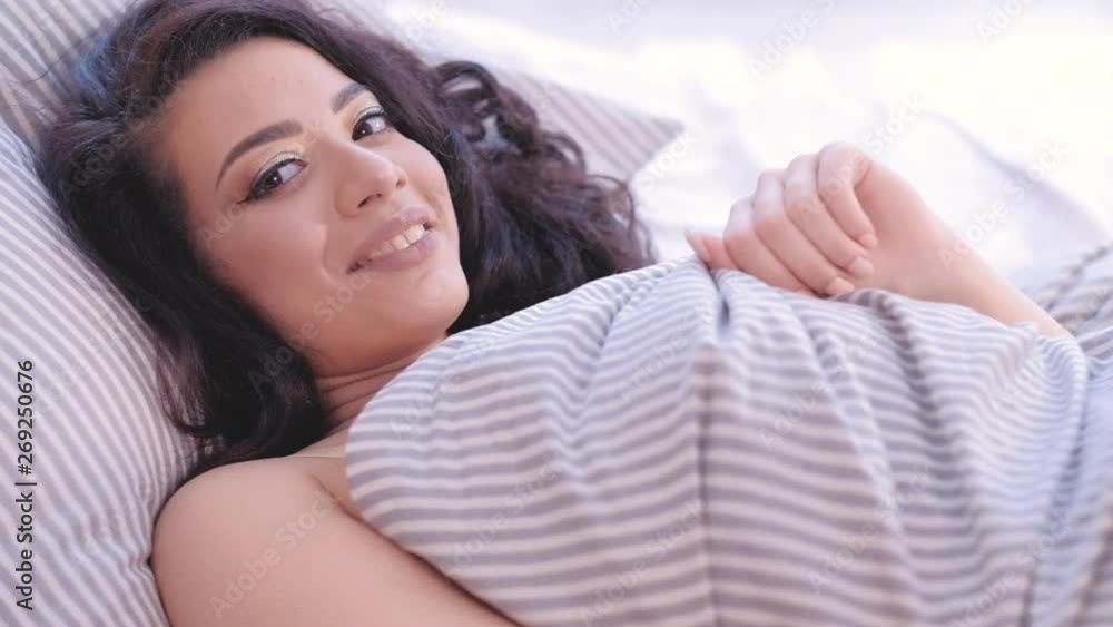 Good morning. Happy woman waking up in her cozy bed at home, smiling. New day beginning. Good morning. Happy woman waking up in her cozy bed at home, smiling. New day beginning.