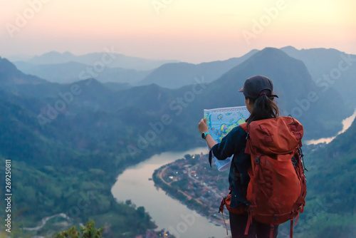 Woman hiker relaxing on a top of a mountain admiring surrounding rocky peaks,Phadeng Peak, Laos in outdoor lifestyle adventure and camping. Travel summer life